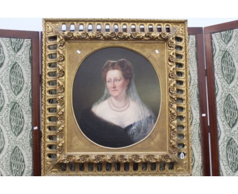 ENGLISH MID 19TH CENTURY SCHOOL. OVAL PORTRAIT OF A LADY IN ELABORATE CARVED OVAL GILTWOOD FRAME. 68 X 60CM