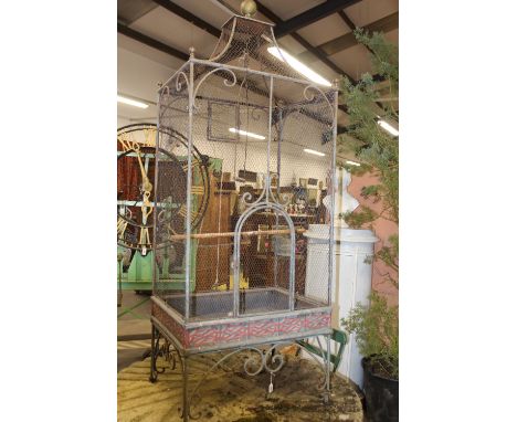 A VINTAGE TOLE AND WROUGHT IRON LARGE PARROT CAGE WITH BRASS FINIAL AND SCROLL SUPPORTS, 180CM HIGH