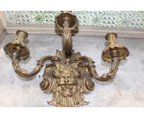 A PAIR OF ANTIQUE FRENCH ORMOLU REGENCY STYLE THREE LIGHT APPLIQUES WITH MASK BACKPLATES