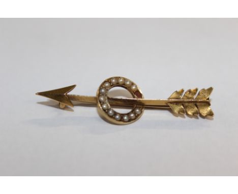 AN EDWARDIAN GOLD COLOURED ARROW BAR BROOCH WITH SPLIT PEARL CENTRE