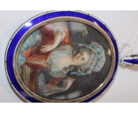 AN OVAL MINIATURE FRENCH PORTRAIT OF A LADY WITH A BIRDCAGE, INDISTINCTLY SIGNED AND DATED IN A BLUE ENAMEL SILVER FRAME, 7 X