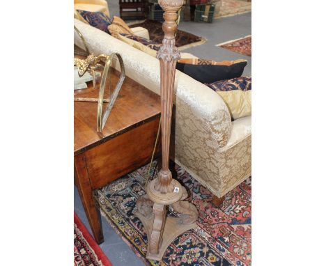 AN ITALIANATE CARVED PINE STANDARD LAMP, A SIMILAR GILDED EXAMPLE AND ONE OTHER