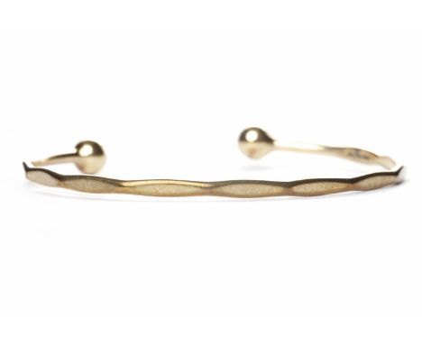 NINE CARAT GOLD TORQUE BANGLE with a diameter of 6.5cm, weighing approximately 9.4g