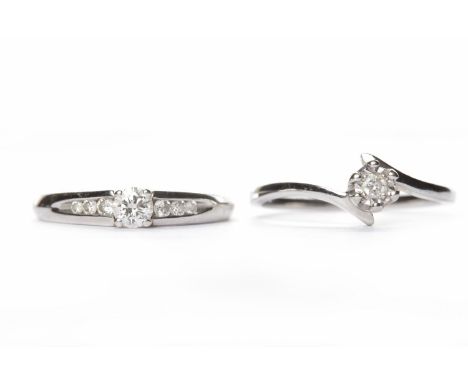 TWO NINE CARAT WHITE GOLD DIAMOND SOLITAIRE RINGSone with the round brilliant cut diamond on channel set diamond shoulders, s