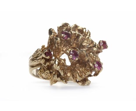 1970S RUBY DRESS RINGthe textured three dimensional bezel set with round rubies, in nine carat gold, size I, 10.6g