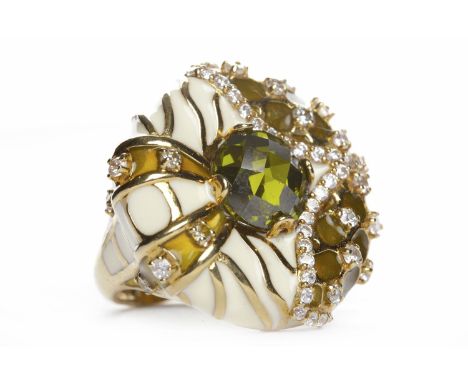 EIGHTEEN CARAT GOLD ENAMEL AND GEM SET RINGthe large round bezel 27mm diameter with white enamel and set with green gems, siz