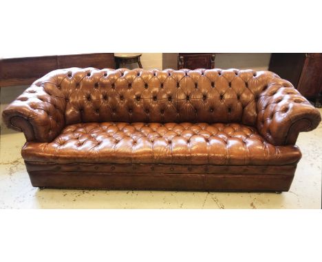 CHESTERFIELD SOFA, hand finished, buttoned tan leather upholstery, on short metal castors, 219cm W x 79cm H x 90cm D.