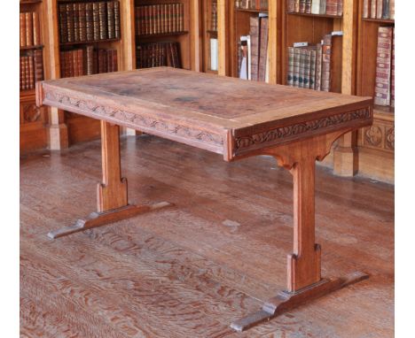 A WILLIAM IV OAK GOTHIC REVIVAL WRITING TABLE the rectangular top inset with a gilt tooled leather writing surface over a lea