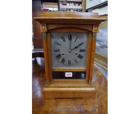 An oak mantel clock, 37.5cm high, with pendulum.