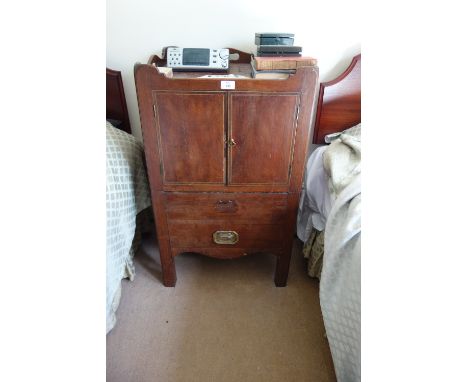 A GEORGE III MAHOGANY BEDSIDE COMMODE the tray-top with pierced hand apertures over a cupboard and a pull-out drawer fitted w