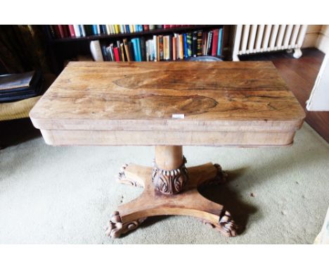 A WILLIAM IV ROSEWOOD CARD TABLE the folding envelope top above a plain frieze, on single shaft with leaf-carved baluster col