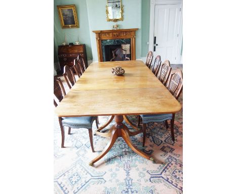 A GEORGE III STYLE MAHOGANY FOUR PILLAR DINING TABLE the rectangular top with rounded edges in four sections, each on a ring-