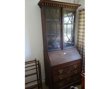 A GEORGE III STYLE PROVINCIAL OAK BUREAU BOOKCASE the upper section with astragal glazed doors enclosing interior shelves sur