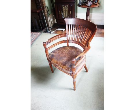 AN EDWARDIAN OAK COMB-BACK OFFICE CHAIR with leather seat, on ring-turned legs, 23" wide 