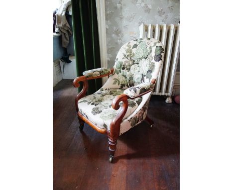 AN EARLY VICTORIAN MAHOGANY SPOONBACK ARMCHAIR upholstered in floral material, on ring-turned tapering legs, brass toes and c