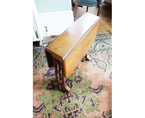 AN EDWARDIAN MAHOGANY SMALL SUTHERLAND TABLE with rectangular drop flaps, on ring-turned legs, 24" wide 