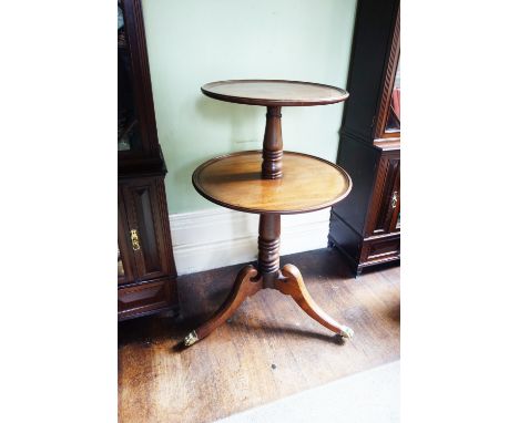 A GEORGE III MAHOGANY DUMB WAITER with two dished circular shelves, on baluster and ring-turned column and tripod downswept l