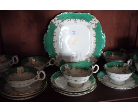 A COALPORT STYLE TEA SERVICE, the cream ground with apple green banding highlighted with gilding. Comprising tea cups, saucer