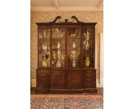 AN EARLY GEORGE III MAHOGANY BREAKFRONT BOOKCASE IN THE MANNER OF THOMAS CHIPPENDALE, the upper section with pierced swan-nec