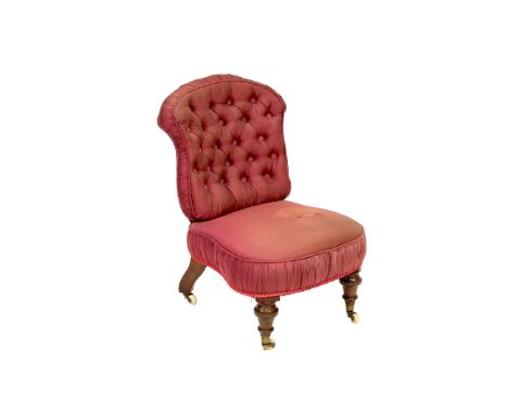 A Victorian child's button back chair,&nbsp;with red silk upholstery raised on turned supports terminating in castors&nbsp;