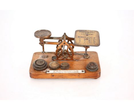 A set of oak and brass postal scales and weights