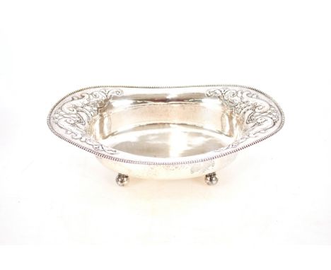 A continental&nbsp;oval white metal bread basket,&nbsp;with foliate embossed decoration raised on ball feet, marked to base .