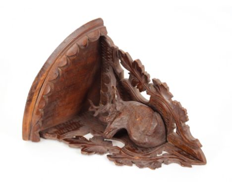 A Black Forest style carved wooden corner shelf,&nbsp;with stag decoration