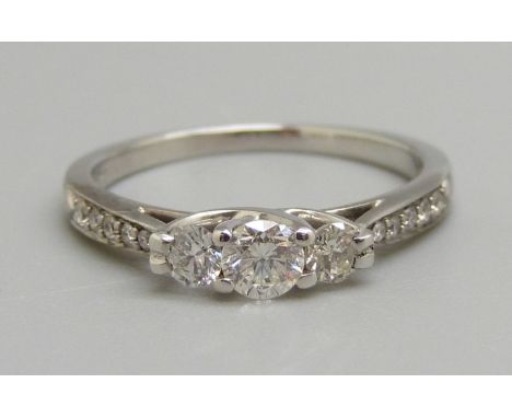 An 18ct white gold three stone diamond ring with diamond shoulders, N, 2.9g, shank marked 0.50ct 