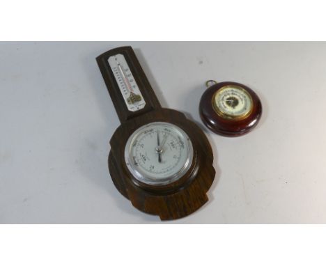 A Mahogany Framed Circular Aneroid Barometer Together with an Oak Mid 20th Century Wheel Barometer with Temperature Scale