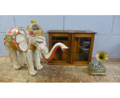 An oak smoker's cabinet, a musical box/lighter and a wooden model elephant 