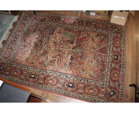 A modern machine made rug of Persian design, decorated with a central panel of trees and birds within stylized borders, 231 c