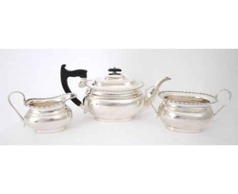 Mid-20th century silver tea service. A three-piece silver tea-service, the gadrooned rim over oblong baluster-shaped body, ha