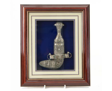 Middle Eastern presentation Jambiya dagger, in a silver sheath with filigree decoration, contained within a framed glazed dis