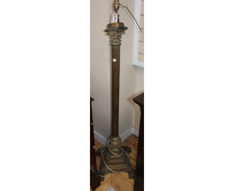 A brass paw footed Corinthian column adjustable standard lamp