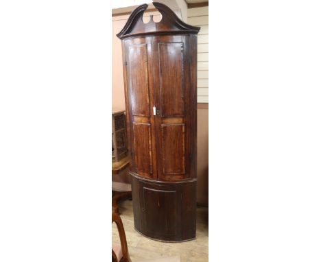 A George III mahogany bow-fronted standing corner cupboard H.230cm