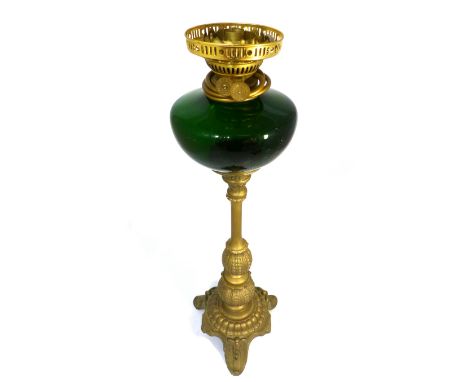 A Victorian style gilt metal table lamp, with green glass shade and reservoir.