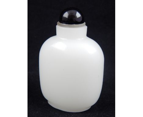 A Chinese white jade snuff bottle, with black stopper. H. 8.5cm