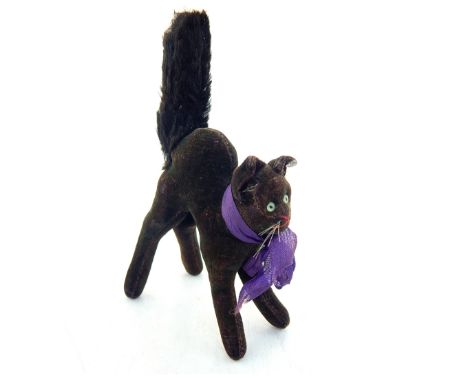 A 1930s Steiff black mohair Tom Cat, with arched back and upright tail, green and black glass eyes, red stitched nose and mou
