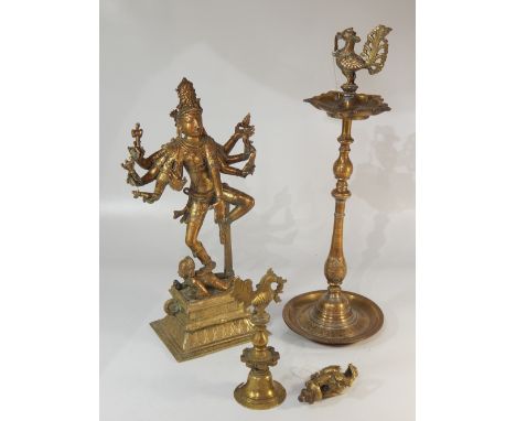 An Indian brass pedestal oil lamp with peacock finial, two other brass peacocks and a large cast brass eight armed Hindu deit