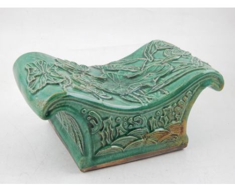 A Chinese green glaze ceramic pillow, applied leaf decoration. W. 23cm