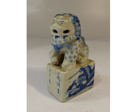 A Chinese temple lion ceramic ink seal, blue and white glaze, landscape and character marks to integral plinth. H. 10.5cm