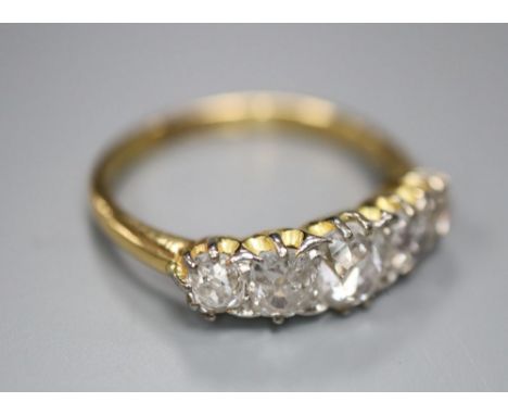 An 18ct gold and diamond five-stone ring, size L/M, gross 3 grams.CONDITION: The largest stone and one of the smaller stones 