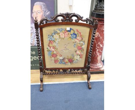 A Victorian rosewood firescreen with armorial tapestry banner, width 75cm, height 105cm
