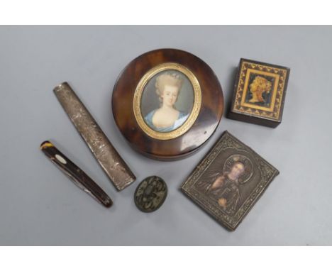 A circular tortoiseshell box, cover inset with portrait miniature, a miniature white metal icon and four other items