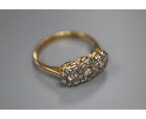 An 18ct yellow and white gold diamond triple cluster ring, size L/M, gross 2.7g