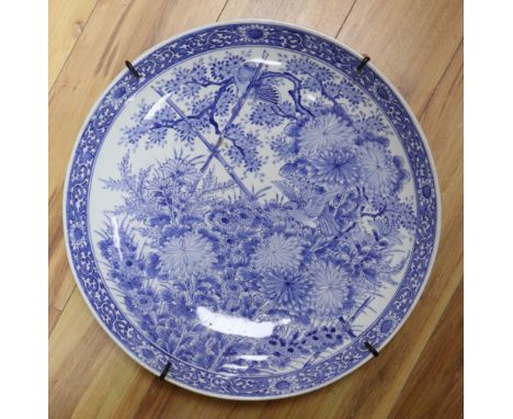 A large Chinese porcelain wall plate, painted with birds and flowering shrubs in underglaze blue