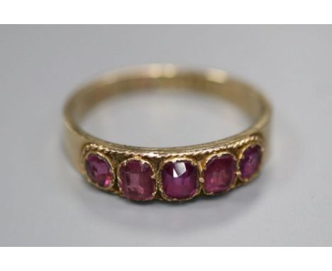 An early 20th century 10ct yellow metal and graduated five stone garnet set half hoop ring, size R, gross 1.9 grams.CONDITION