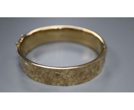 A 9ct engraved gold hollow hinged bangle, Cropp &amp; Farr, Birmingham 1974, 20.9g.