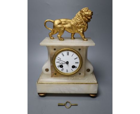 A 19th century French eight day alabaster mantel clock, surmounted by a gilt metal model of a lion, bell striking movement, 3