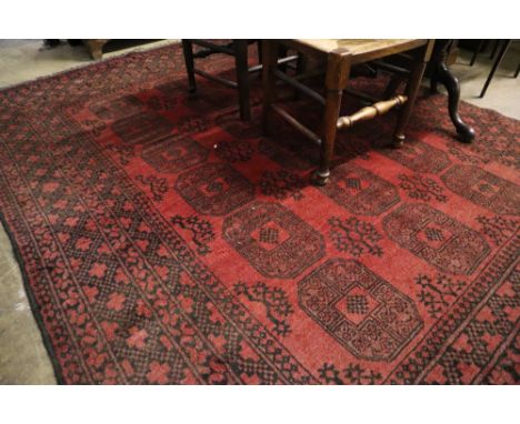 An Afghan burgundy ground carpet, 290 x 208cm